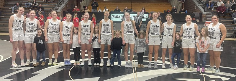 a row of girls standing in the gym for the girls basketball game