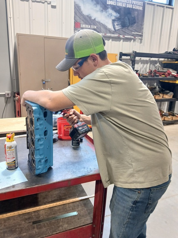 an auto tech student making a repair