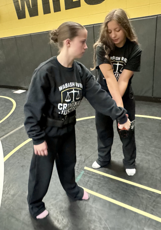 two criminal justice students learning safety skills