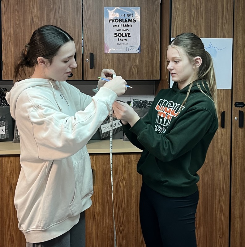 two students trying to measure a circle item