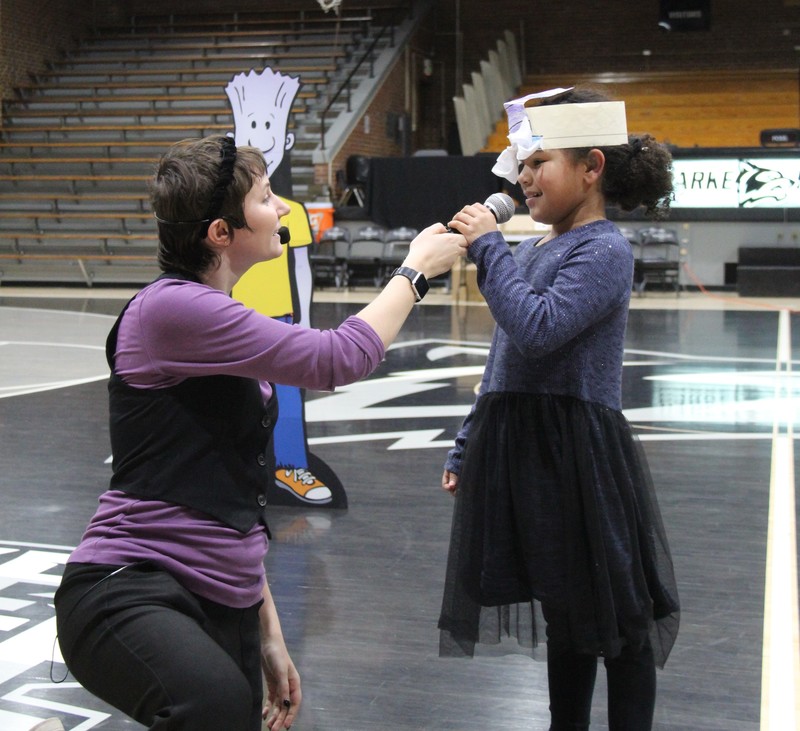 a woman talking to a girl on the gym floor