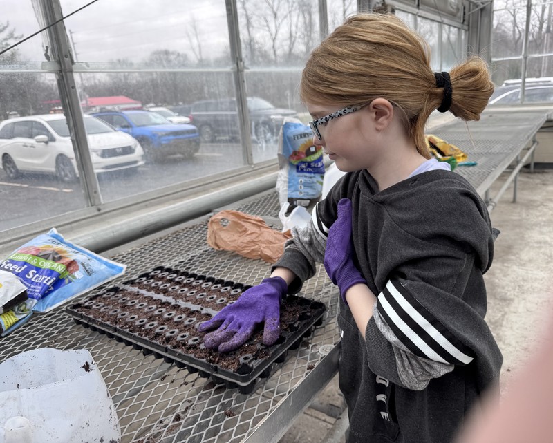students planting seeds in a greenhouse