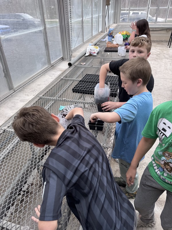 students planting seeds in a greenhouse