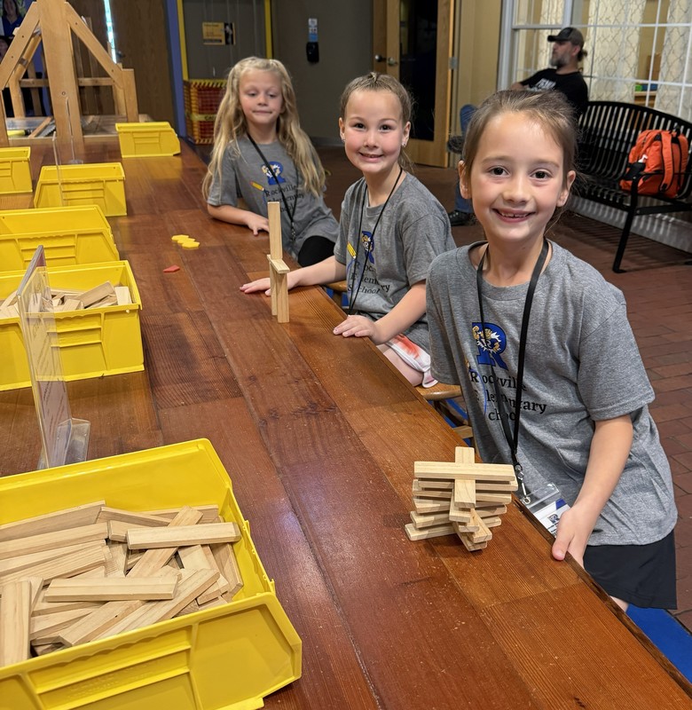 three students playing with blocks