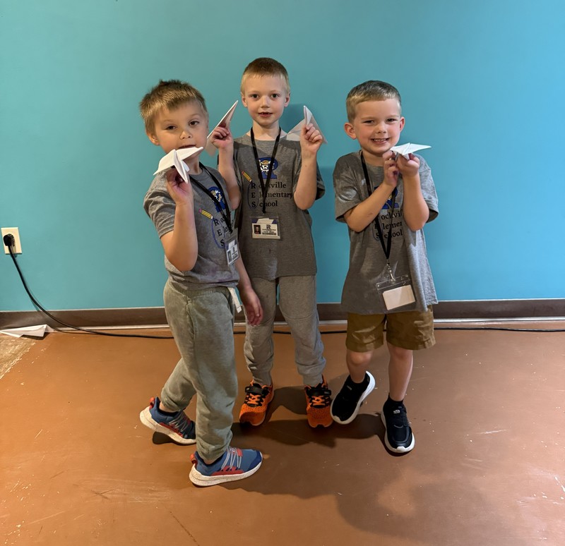 three boys with paper airplanes