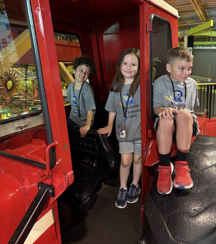 three students on a tractor