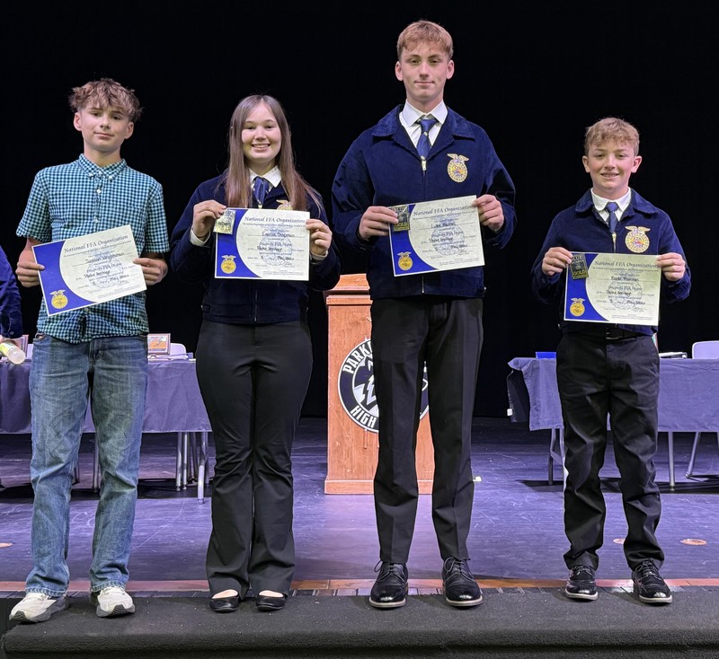 four FFA members standing in a line holding certificates