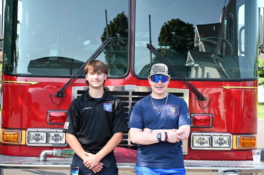 Two students stand in front of fire truck 