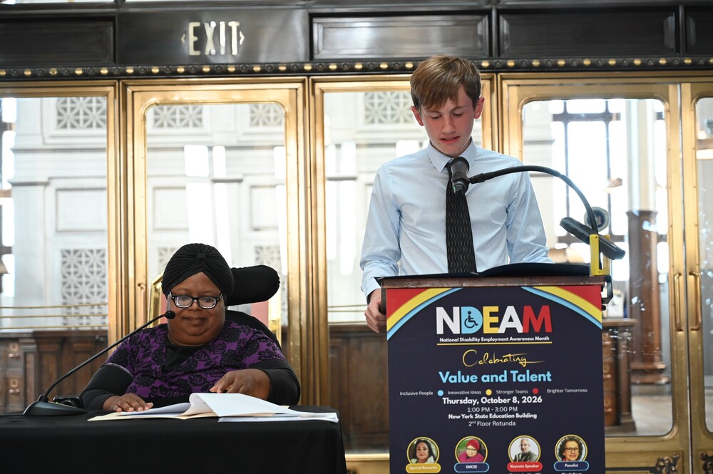 Shaker student David Terrell reads a proclamation from a podium at the front of the room.