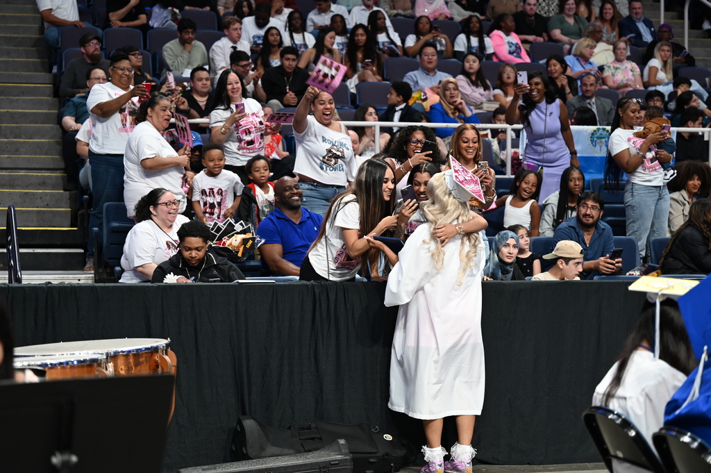 A Shaker graduate stops for hugs from family members and friends.