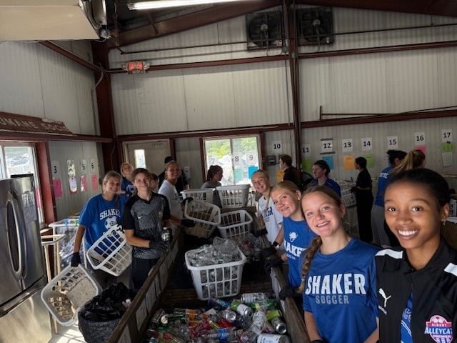Girls soccer team members helping sort bottles and cans