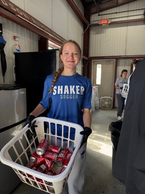 Girls soccer member with sorted cans