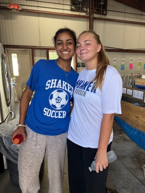 Girls soccer team members helping sort bottles