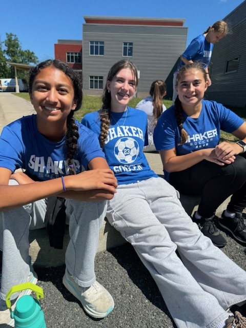 Girls soccer team sitting outside
