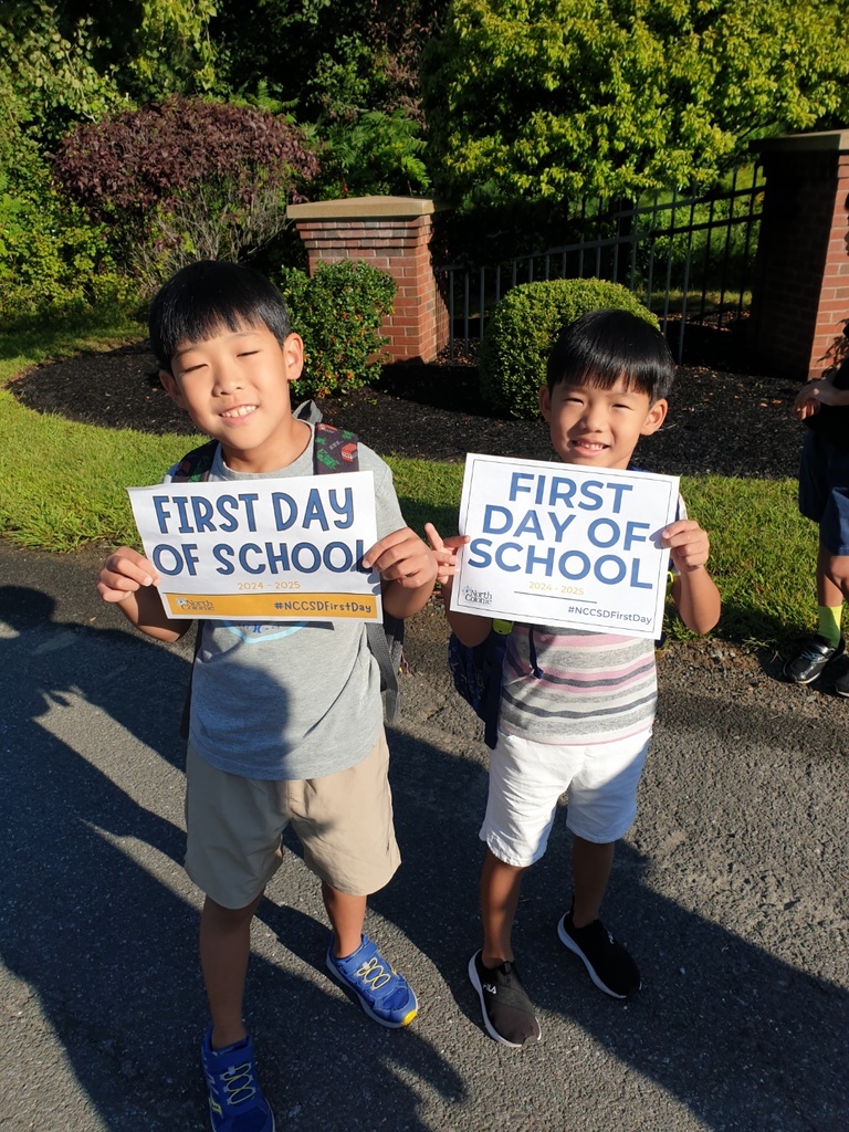 Students holding first day of school signs