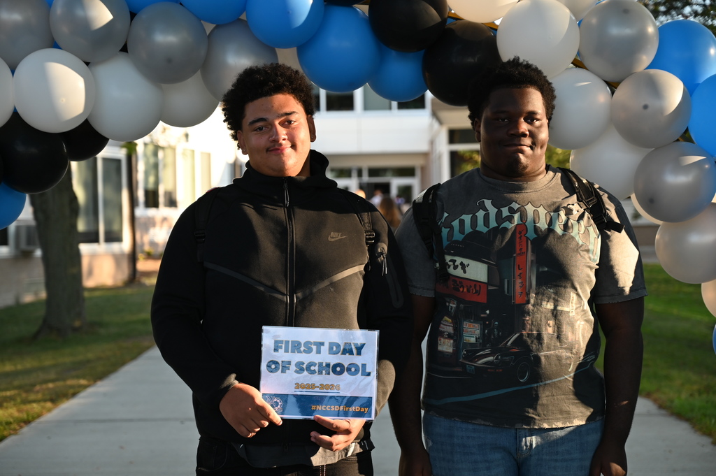 Students on the first day holding sign