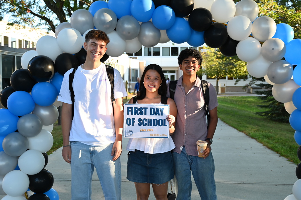 Students on the first day holding sign