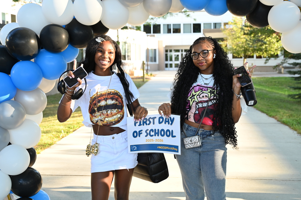 Students on the first day holding sign