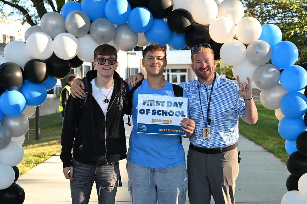 Students on the first day holding sign with Garrett