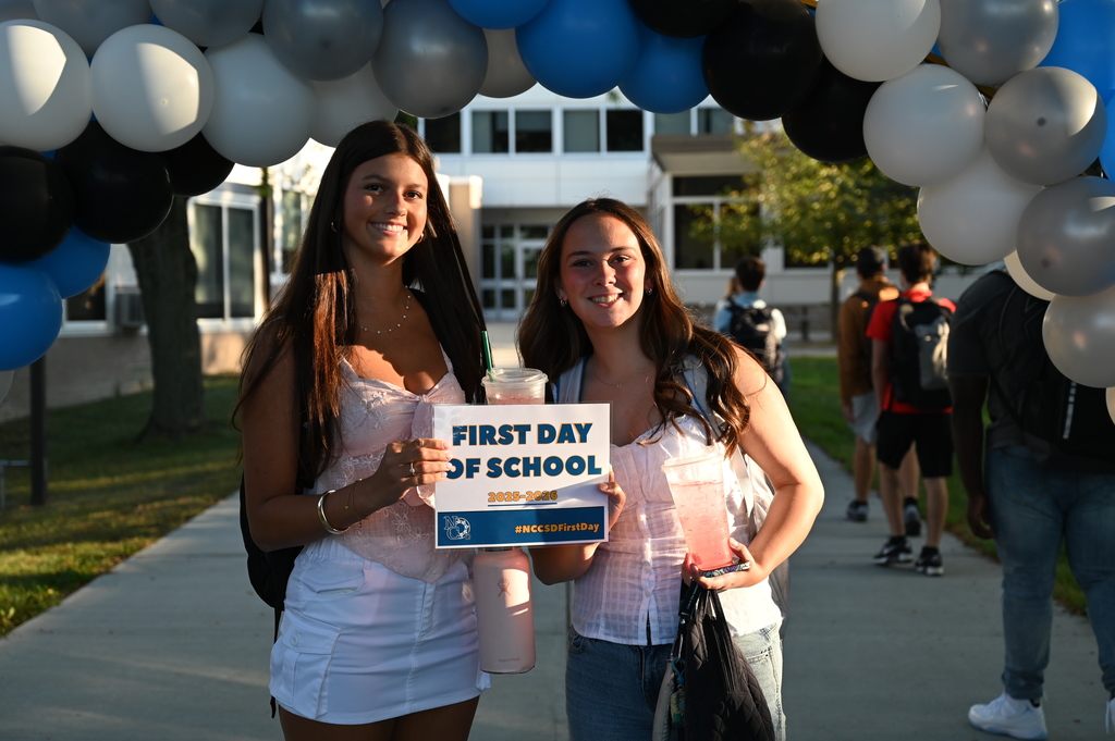 Students on the first day holding sign