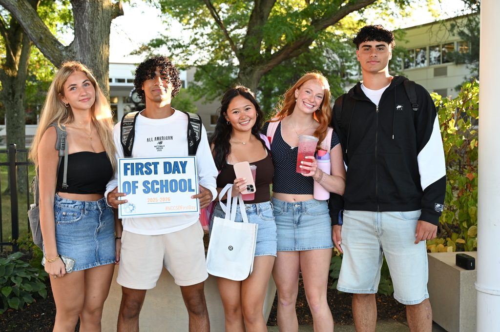 Students on the first day holding sign