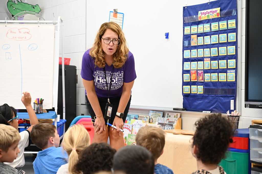 A teacher speaks to her class of kindergarten students.