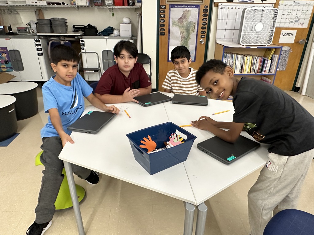 Four students pose around a table in lab.