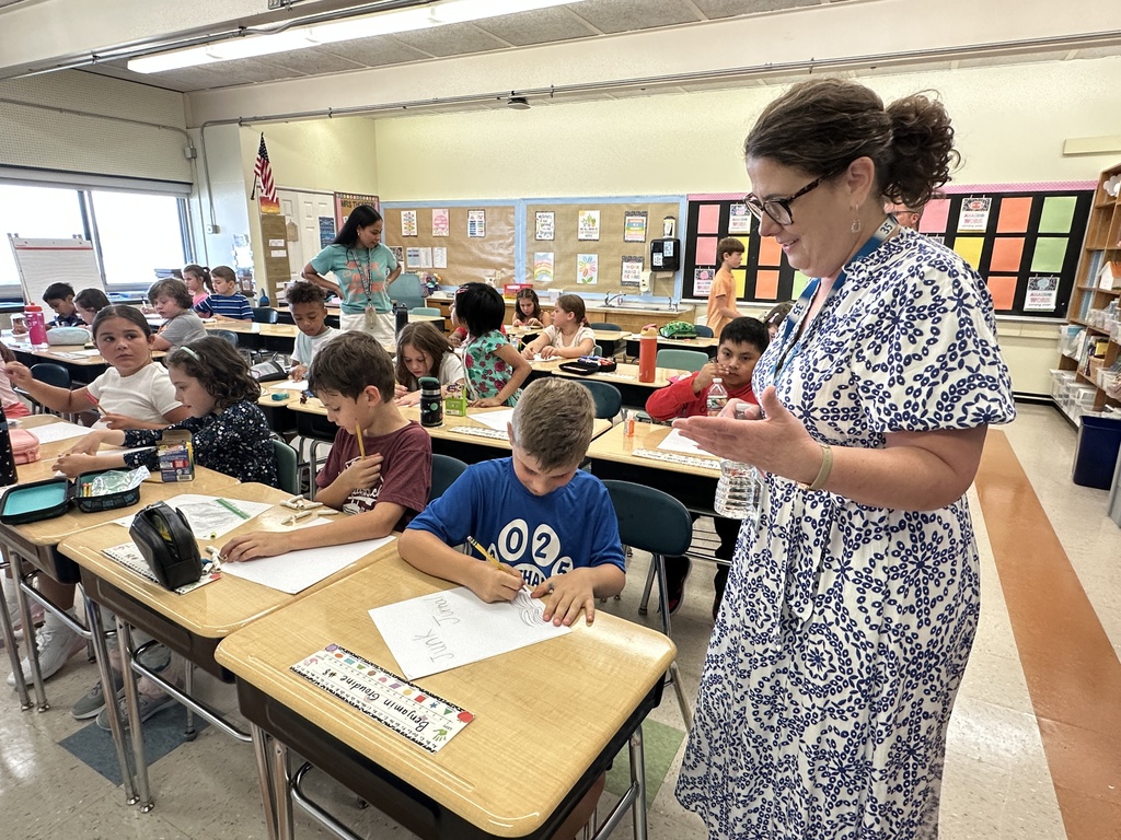 Superintendent Kathleen Skeals learns about a journal from a young student.