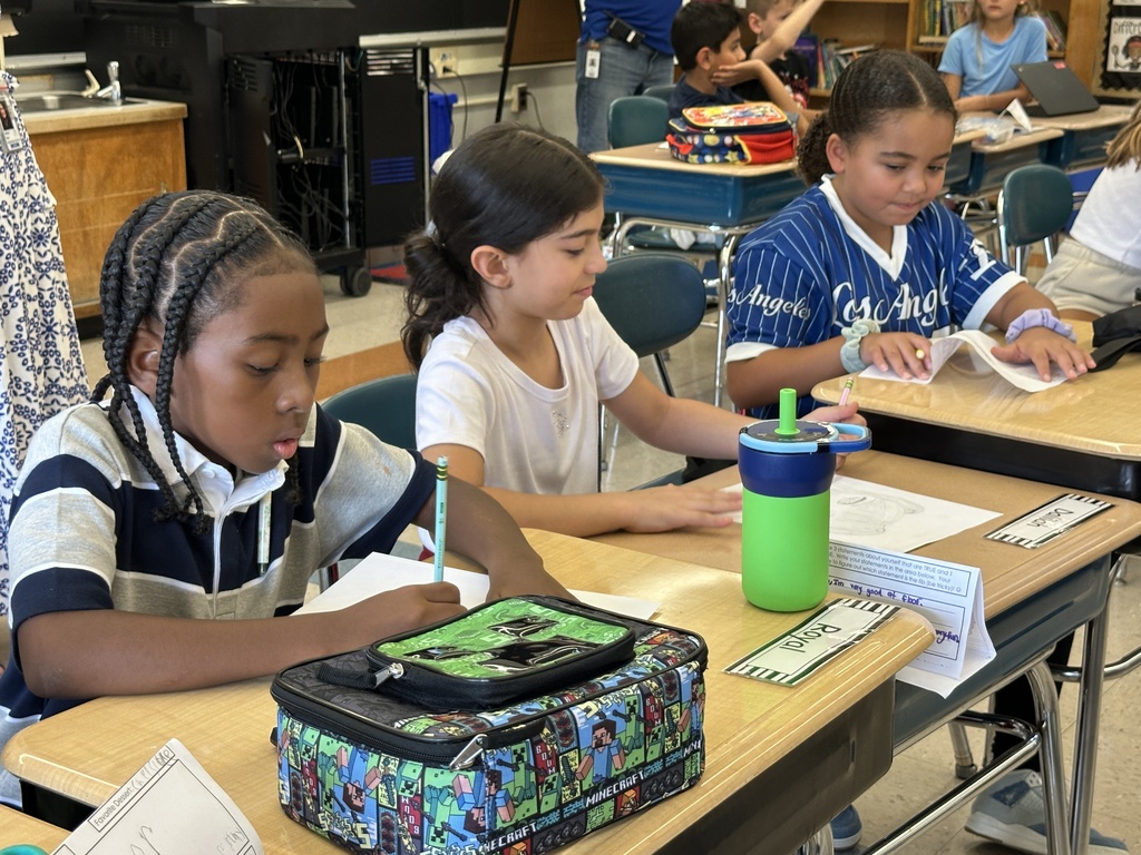 Three students work at their desks.
