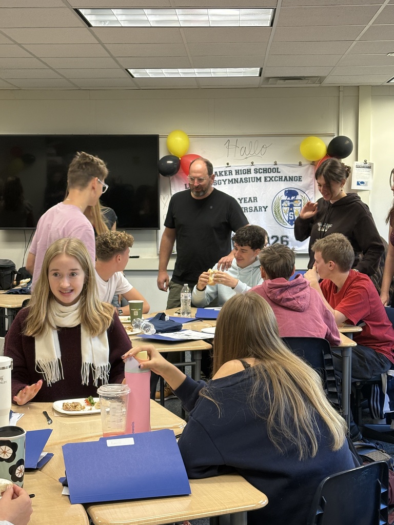 German exchange students enjoying breakfast and chatting with their teacher