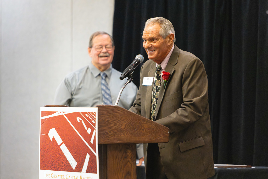 Shaker alum and former Athletic Director Dave Herman speaks at a podium during his induction ceremony.