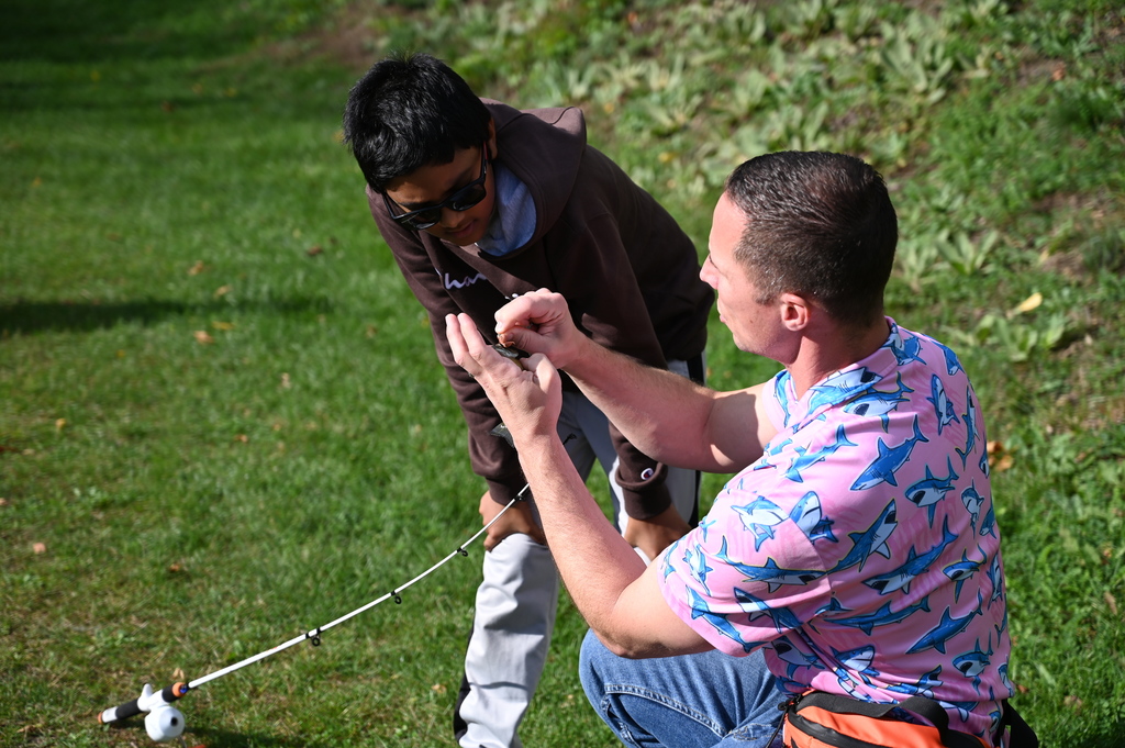 SMS teacher and fishing club advisor shows student how to properly hold a fish