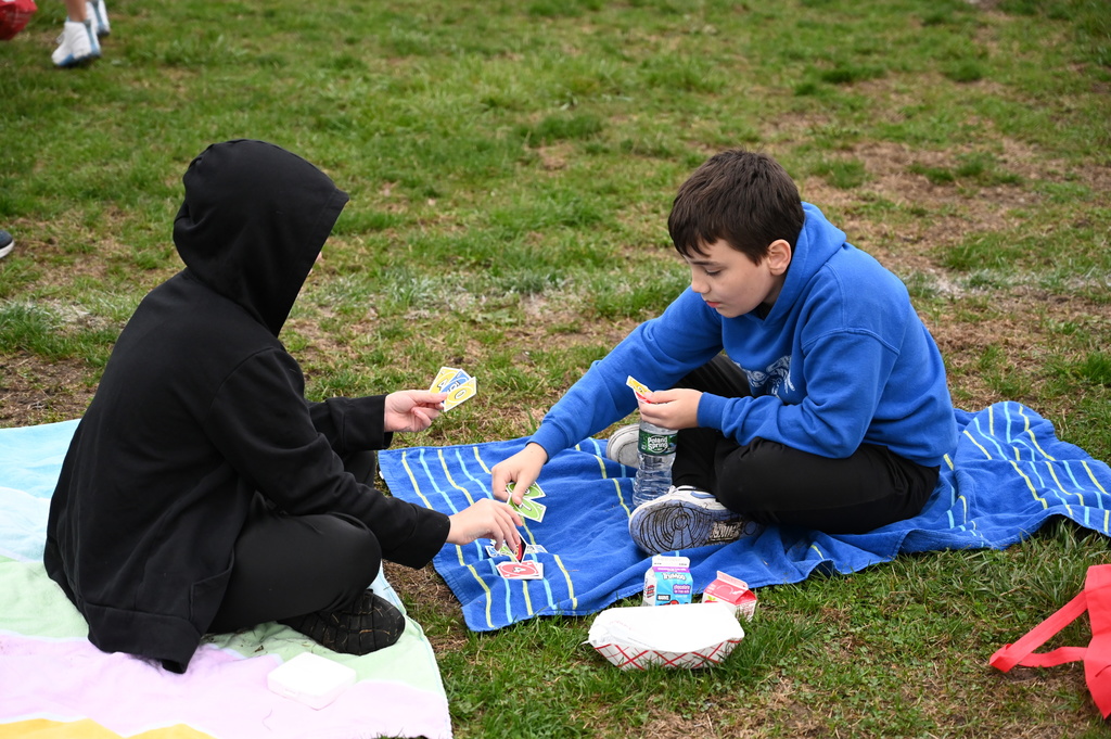 Students play Uno while waiting their turn to race