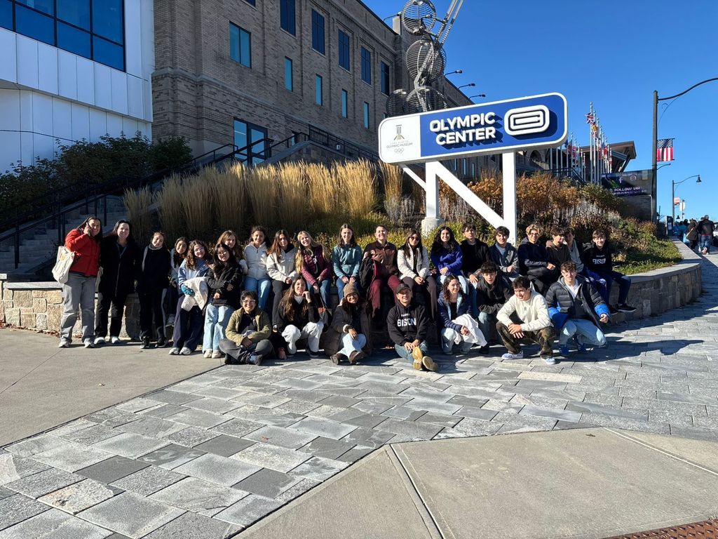 A large group poses in front of the Olympic Center in Lake Placid.