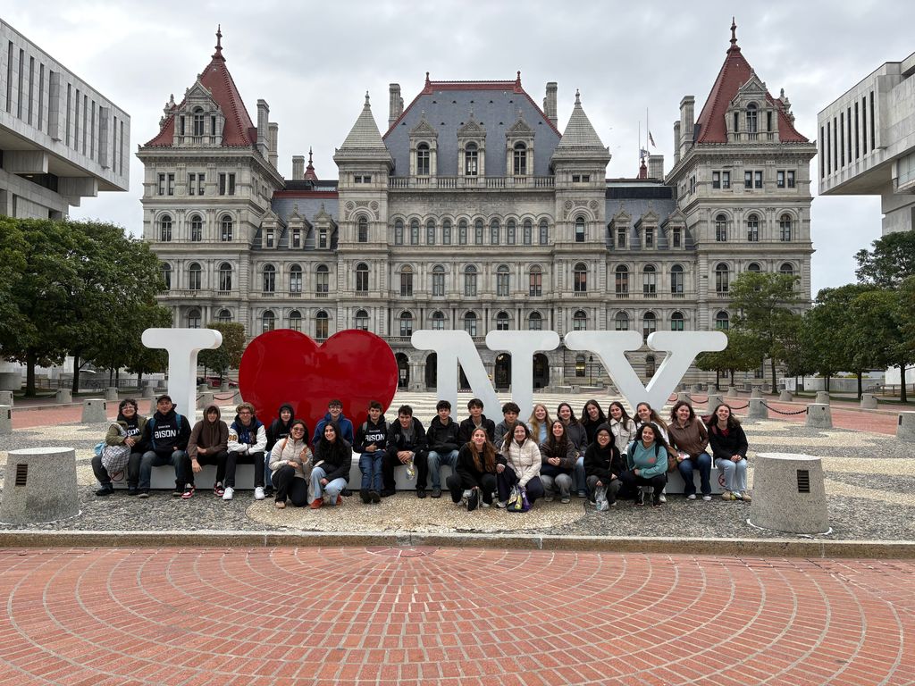 Students pose in front of the NYS Capitol building and I Love NY sign.