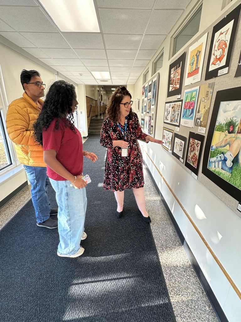 A student discusses her artwork on display with Superintendent Kathleen Skeals.