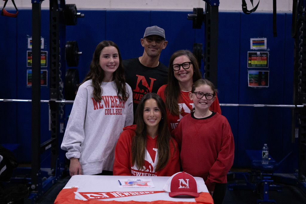 A student and her family members pose after signing her letter of intent.