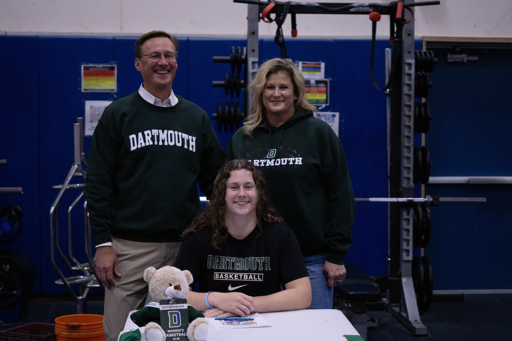 A student and her family members pose after signing her letter of intent.