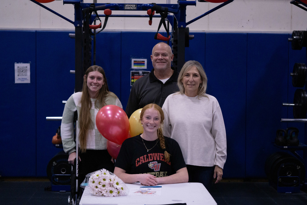 A student and her family members pose after signing her letter of intent.