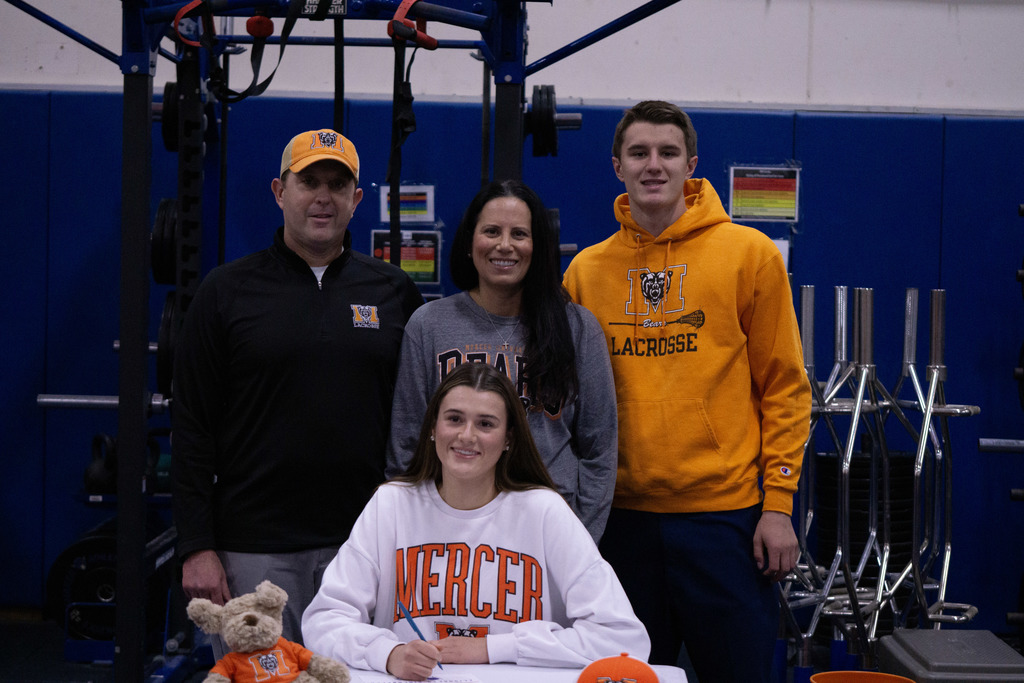 A student and her family members pose after signing her letter of intent.