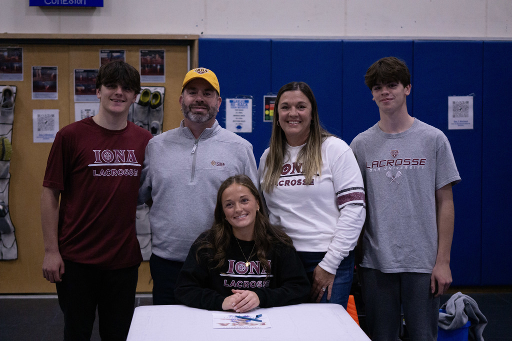 A student and her family members pose after signing her letter of intent.