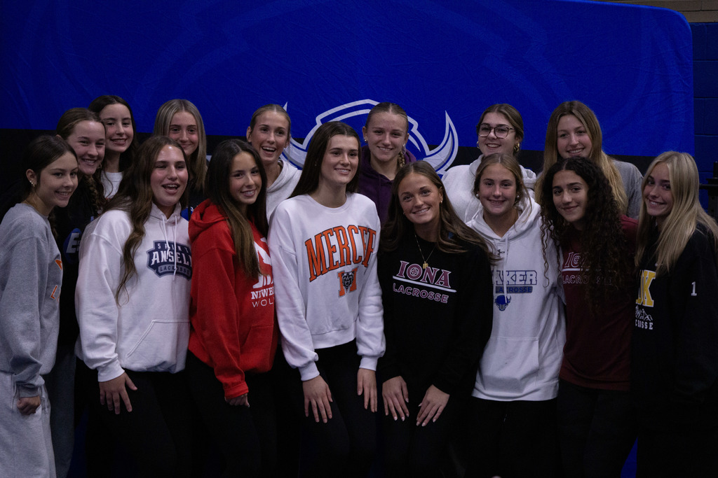 Members of the Shaker girls lacrosse team pose together with four of their teammates who signed letters of intent.