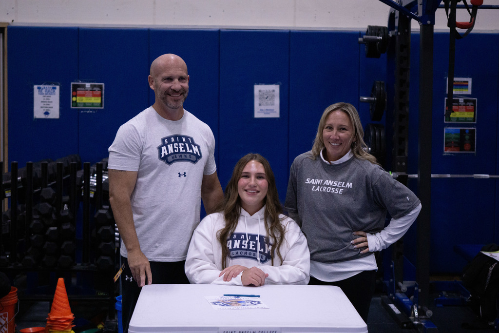 A student and her family members pose after signing her letter of intent.