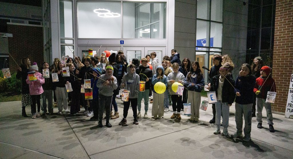 Dozens of students pose in front of Shaker Middle School with lanterns for Martinstag.