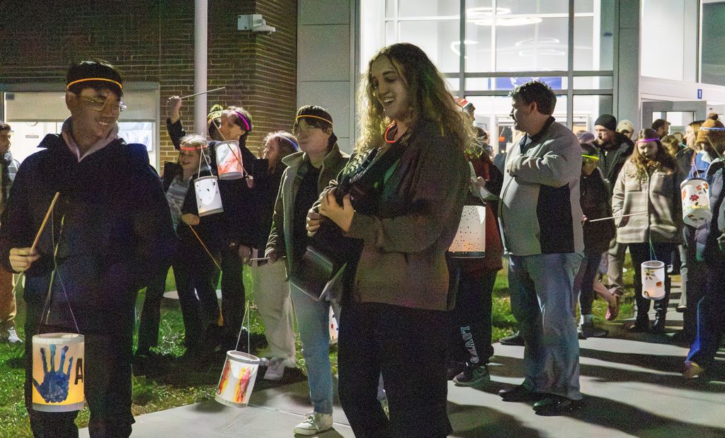 One student plays a guitar during the lantern parade outside.