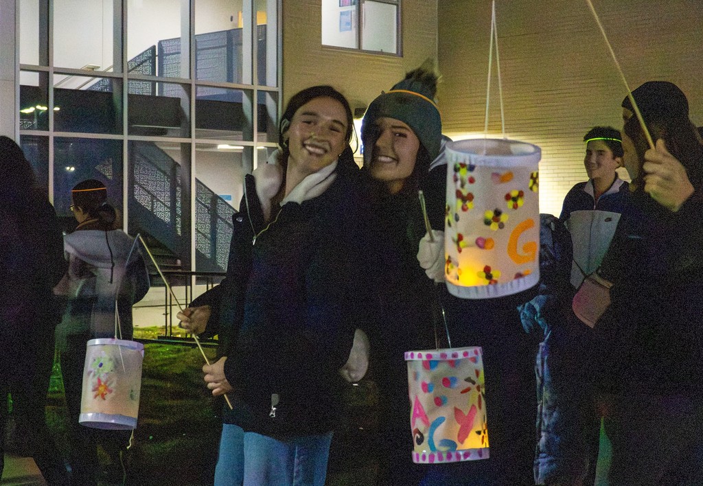 Two students pose together with lighted lanterns.