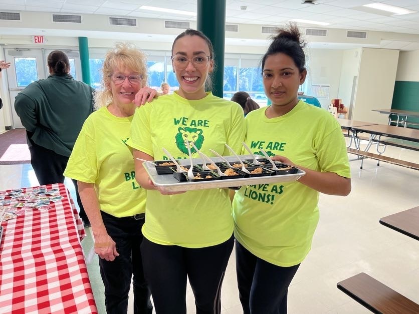 The Awesome Forts Ferry team holds up apple crisp for Harvest of the Month