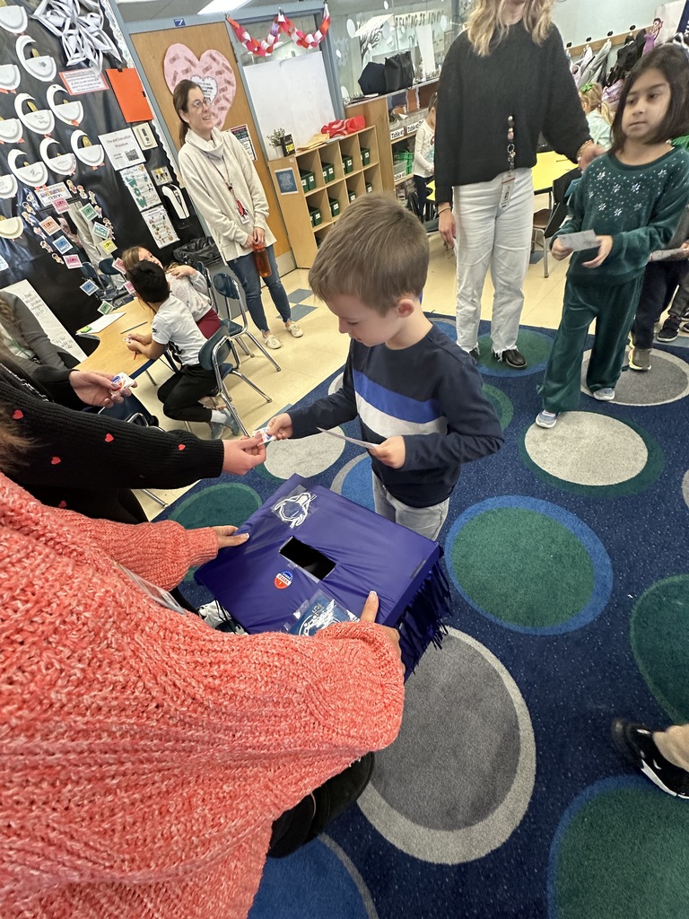 Student puts in ballot and gets sticker