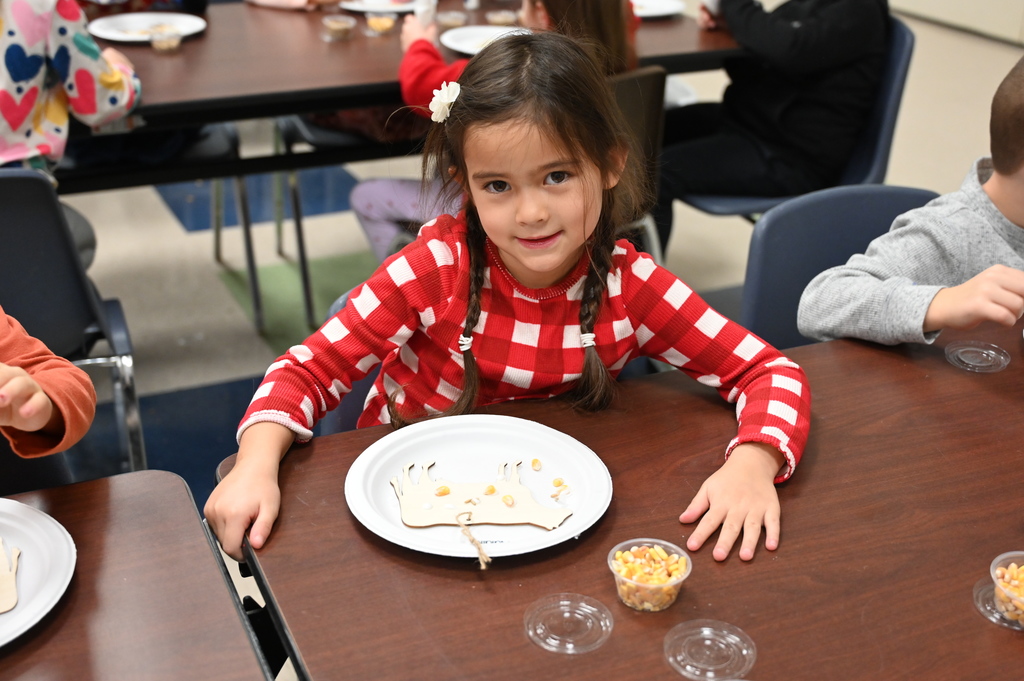 A student poses with the project she is creating on a plate.