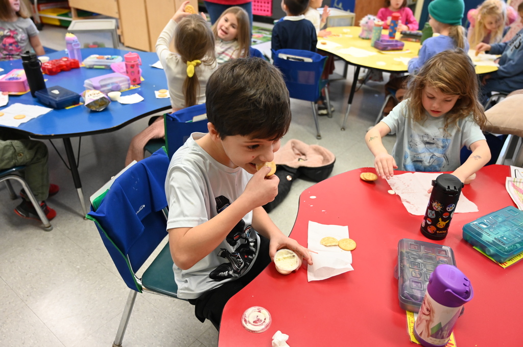 A student tries the butter he made, using a cracker.